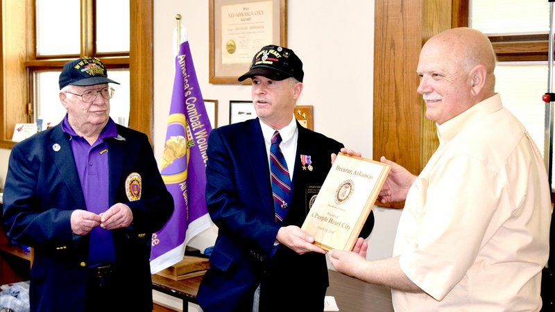 Photo by Mike Eckels Mayor Bob Tharp (right) receives a plaque naming the city of Decatur &#8220;A Purple Heart City&#8221; from Chuck Adkins (center) and Ray E. Poynter with the Purple Heart Trails and Cities Program during the Decatur City Council meeting March 14.