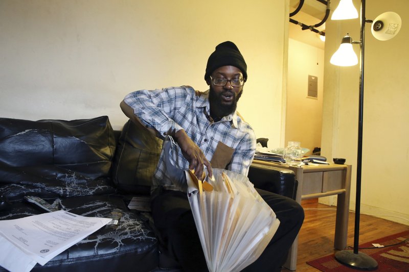 In this Feb. 24, 2016 photograph, Phil Dume, who uses marijuana to treat post-traumatic stress disorder, looks through some of his correspondence with the Veterans Administration at his home in Trenton, N.J. 