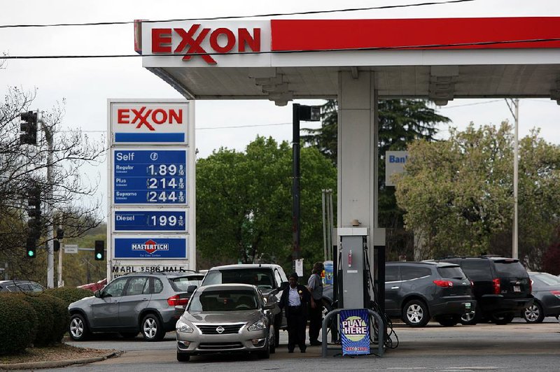 Customers pump gas Wednesday at an Exxon station at McCain and North Hills boulevards in North Little Rock. In Arkansas, the average price of regular unleaded was $1.85 a gallon Wednesday.