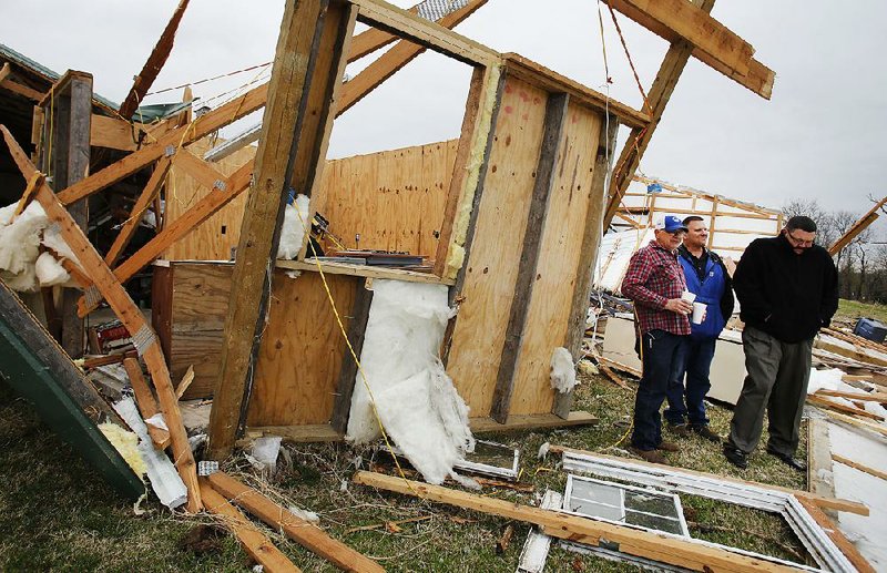 Terry Hudson (from left), Bill Grady and James Carey stand Thursday in the debris of Hudson’s workshop near Evansville in Washington County. Wednesday night’s storm destroyed the structure and did extensive damage to Hudson’s home.