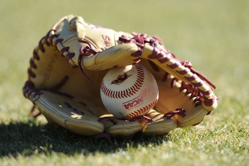 Arkansas ball and glove sits on the field Friday, Jan. 29, 2016, during practice at Baum Stadium in Fayetteville.