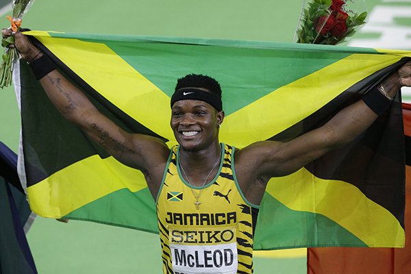 Jamaica's Omar McLeod holds a flag after he won the men's 60-meter hurdles final during the World Indoor Athletics Championships, Sunday, March 20, 2016, in Portland, Ore. (AP Photo/Rick Bowmer)
