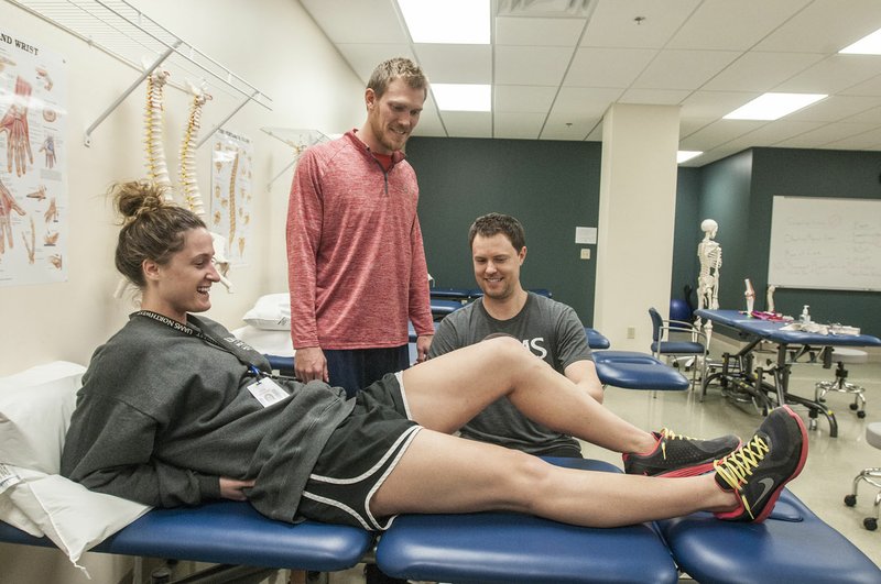 Scott Van Camp (right) demonstrates how to measure range of motion on Gracie Frizzell as Kyle Roliard, all University of Arkansas for Medical Sciences physical therapy students, looks on Thursday, Dec. 10, 2015 at the school in Fayetteville. The school is finishing its first semester in Fayetteville.