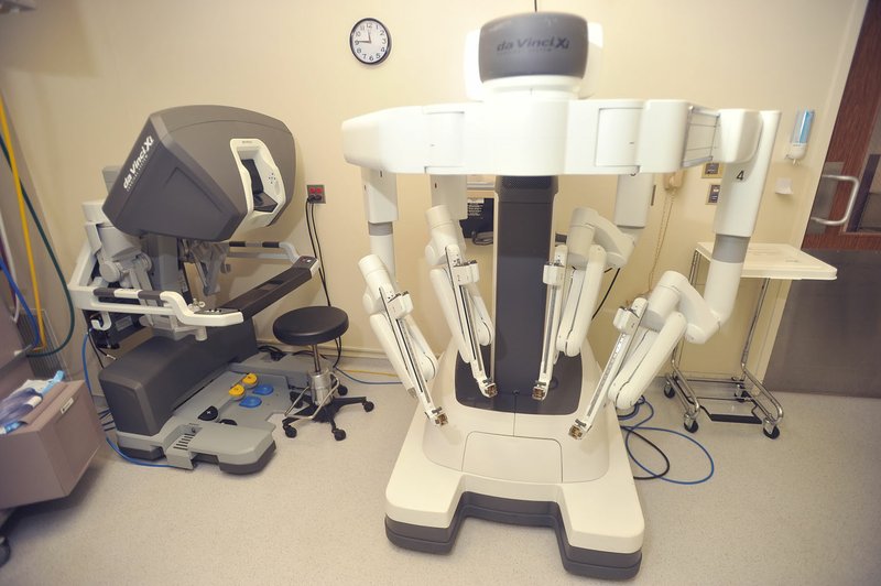 The da Vinci Surgical System seen at the Northwest Medical Center in Springdale, Thursday, February 11, 2016, can be used by surgeons from the control panel (left) to control the 4 robot arms (right) that can each be fitted with a different tool during surgeries.