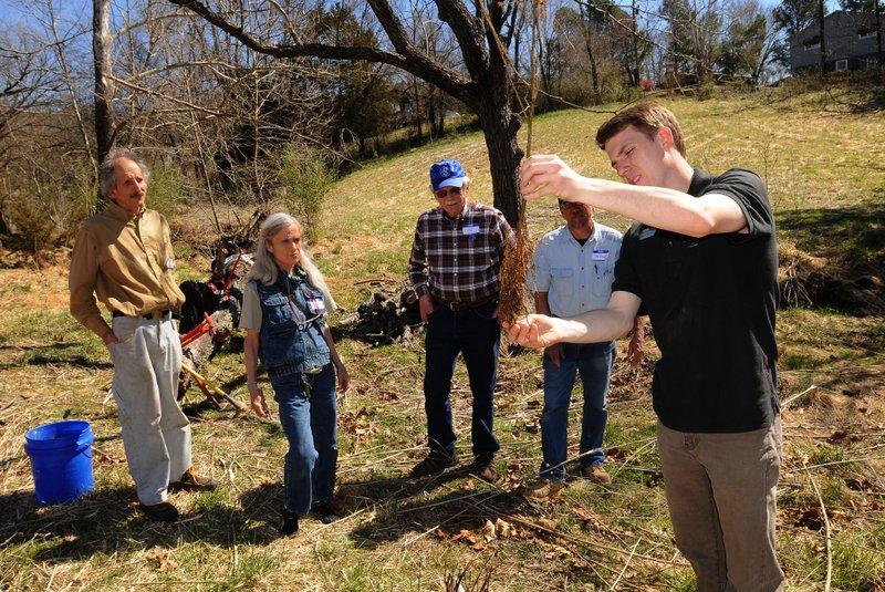 Bryant Baker with Beaver Watershed Alliance (right) shows volunteers how to plant seedling trees to prevent stream-bank erosion. Volunteers included Ricky Candrilli (from left) and his wife, Ginger.