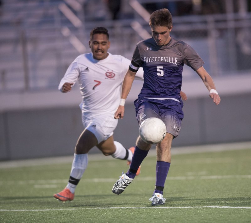 Fayetteville’s Jon Fagg (right) keeps the ball away Tuesday from Springdale High’s Felix Vargas.