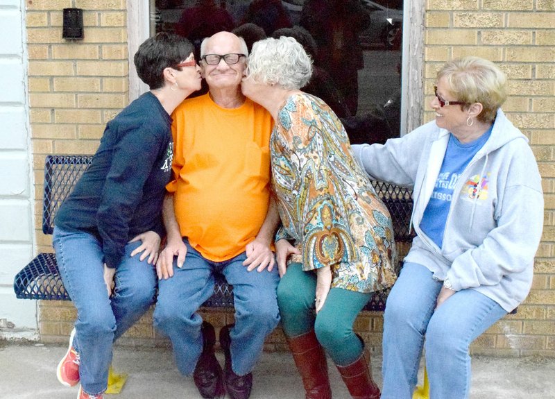 Steven Hall (center) receives kisses from his three sisters on his new bench on Main St. in Decatur March 12. Michal Montgomery (left), Ellen Flores and Pat Weide helped Hall celebrate his 70th birthday at the Gallery Cafe in Decatur.