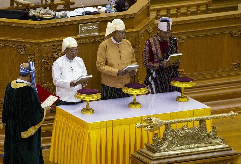 Htin Kyaw (center) takes the oath as Burma’s president at a ceremony Wednesday in parliament in Naypyitaw as the country officially ends more than 50 years of military rule. Htin Kyaw, 70, a trusted aide to ruling-party leader Aung San Suu Kyi, pledged to work toward national reconciliation alongside Suu Kyi, who will continue to hold influence, as will the military through constitutional manipulations. 