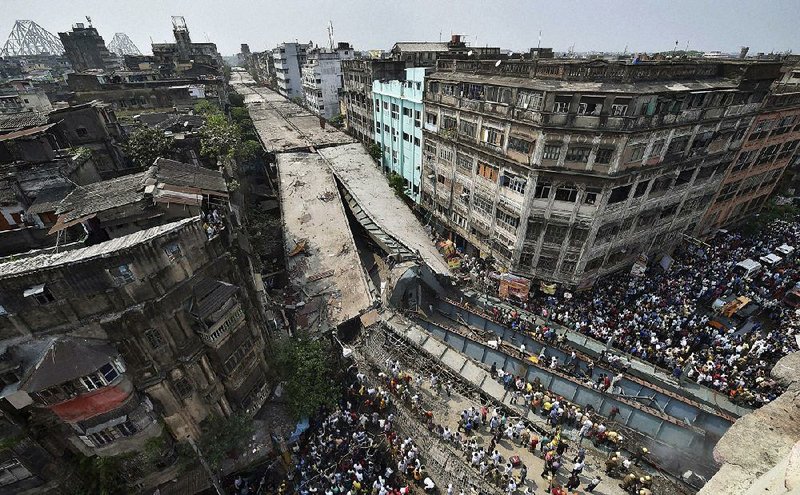 Rescuers work to clear the rubble after an overpass under construction in Kolkata, India, collapsed Thursday, killing at least 22 people and injuring dozens. More people were feared trapped in the fallen girders and concrete. A disaster official called the rescue operation a “very, very challenging task.”