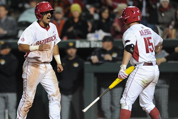 Arkansas shortstop Michael Bernal (left) celebrates after scoring against Missouri with Jake Arledge Friday, April 1, 2016, during the sixth inning at Baum Stadium in Fayetteville.