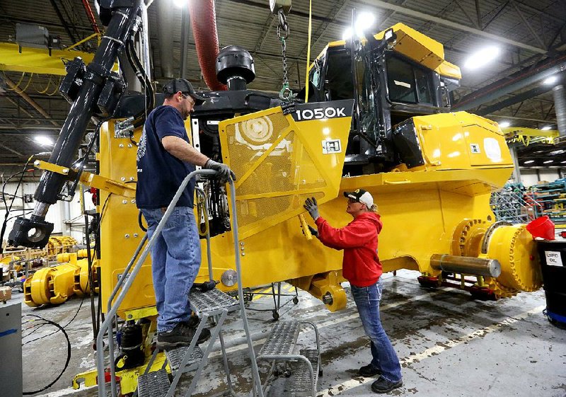 Workers attach a panel to a John Deere 1050K Crawler Dozer at a Deere plant in Dubuque, Iowa, in this file photo. Even during last month’s steady hiring streak, manufacturing posted another month of job losses. 
