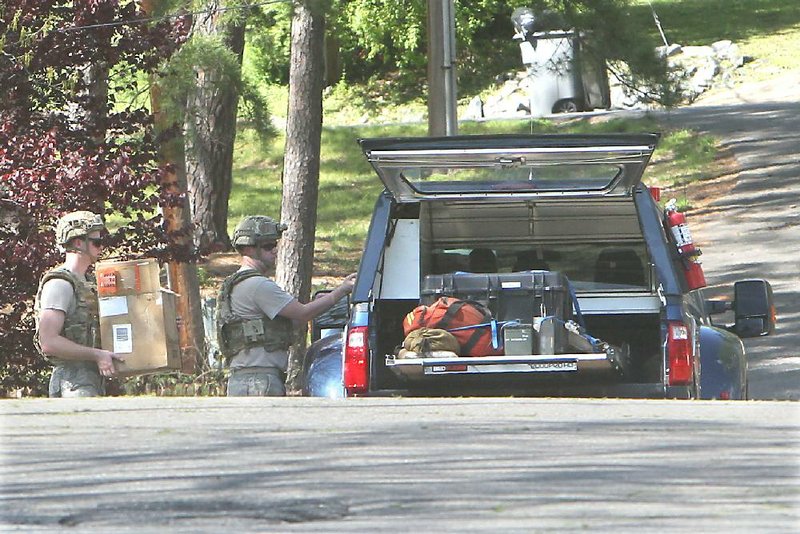 A Little Rock Air Force Base EOD team loads into their vehicle on Woodbeery Street what was initially believed to have been an old cannonball or landmine found on an excavation site near Danville.  (The Sentinel-Record/Richard Rasmussen))