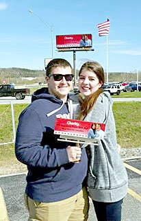 Photo submitted Noah Madryga and Charity Oris pose beneath the digital billboard Noah rented to invite Charity to prom. She said yes.
