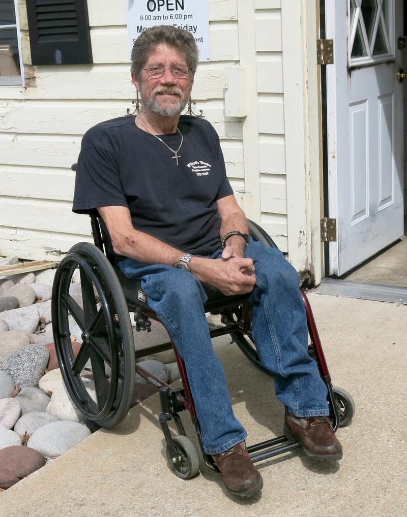 Photo by Susan Holland Mike von Ree, one of the five charter members of the Gravette Historical Museum Commission, remains busy with city and family activities and with his business despite being confined to a wheelchair. Mike von Ree posed in front of the business, Wizard&#8217;s Works, he operates next door to his home on Main Street.