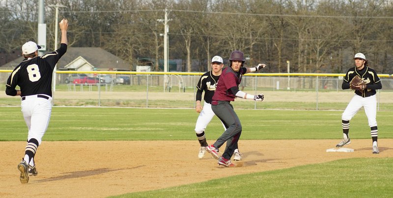 Photo by Randy Moll Zac Adkins, of Gentry gets caught in a pickle between second and third during play against West Fork on Friday. Adkins manages to dive into second and beat the tag.