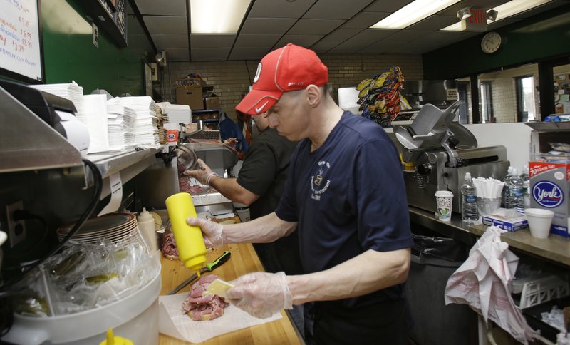 In this Jan. 23, 2015 photo, Mark Childers puts a topping on a corned beef sandwich at the Superior Restaurant in Cleveland. 
