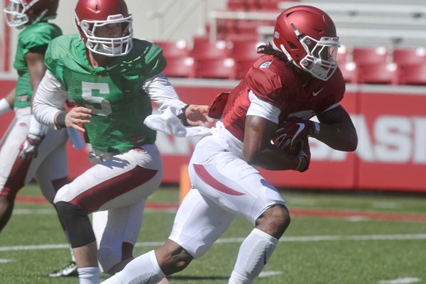 Arkansas quarterback Ty Storey and running back Damon Mitchell (7) run drills during practice Saturday, April 2, 2016, at Razorback Stadium.