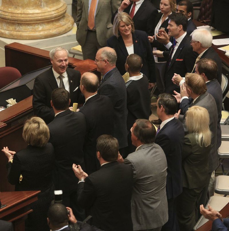 Gov. Asa Hutchinson greets state senators Wednesday after addressing a joint session of the Legislature to open a special session on his plan for the state’s expanded Medicaid program. 