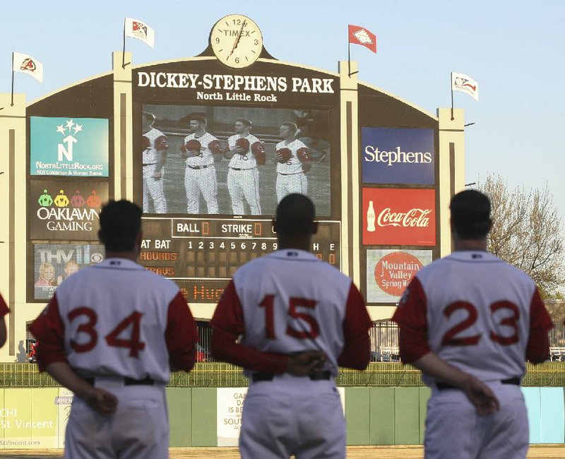 FILE — Arkansas Travelers players listen to the national anthem prior to their game at Dickey-Stephens Park in North Little Rock.