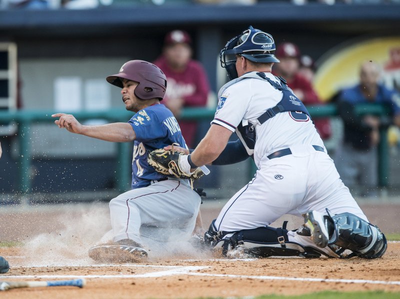 Zane Evans (right) catcher for the Northwest Arkansas Naturals tags shortstop Isiah Kiner-Falefa of the Frisco RoughRiders out at home Thursday at Arvest Ballpark in Springdale.