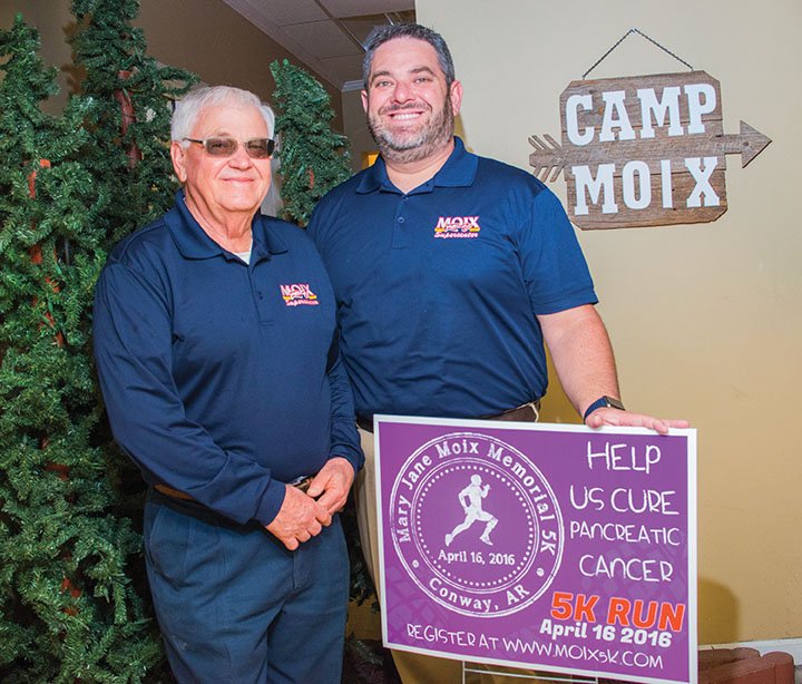 Frank Moix Sr., left, and his son Michael Moix stand with a yard sign advertising the first Mary Jane Moix Memorial 5K, scheduled for Saturday. Frank said he hopes the race, in memory of his wife, will raise money to help cure pancreatic cancer. Registration is at www.moix5K.com.