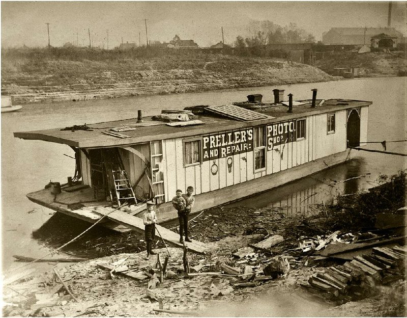 Hugo and Gayne Preller set off on this floating photo studio and fix-it shop, stopping in early-day towns along with Mississippi and White Rivers.