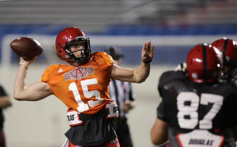 Arkansas State quarterback Justice Hansen (left) looks for an open receiver during Friday night’s scrimmage at War Memorial Stadium in Little Rock. Hansen, a junior college transfer, unofficially completed 14 of 19 passes for 113 yards and directed 2 scoring drives.