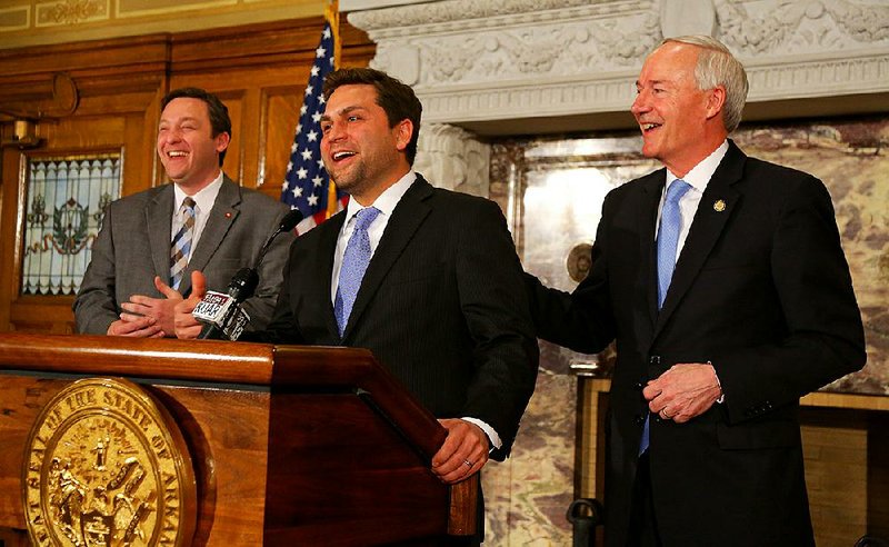 House Speaker Jeremy Gillam (from left) and Senate President Pro Tempore Jonathan Dismang laugh Friday as Gov. Asa Hutchinson offers them up to answer questions about next week’s fiscal session. 