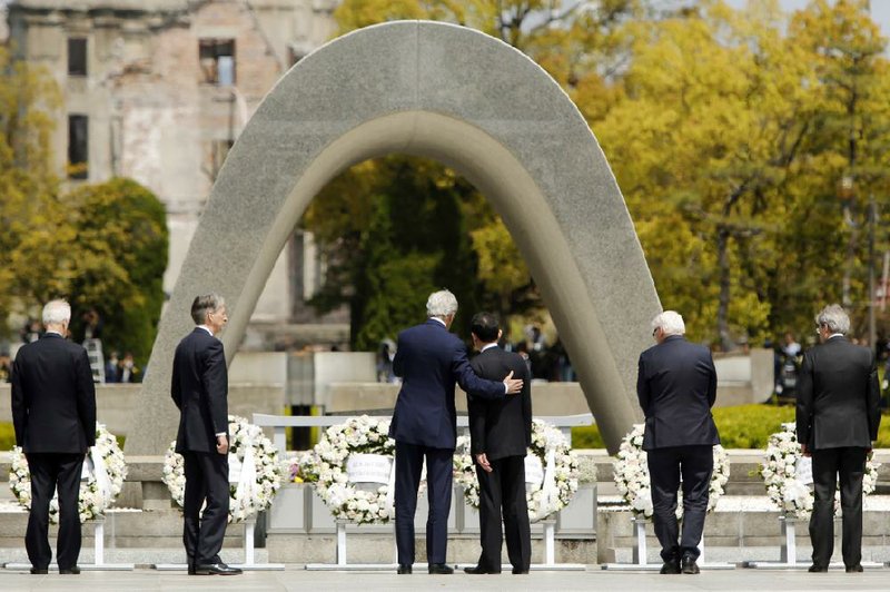 U.S. Secretary of State John Kerry puts his arm around Japanese Foreign Minister Fumio Kishida after they and other Group of Seven foreign ministers laid wreaths today at Hiroshima’s Peace Memorial Park in Japan.