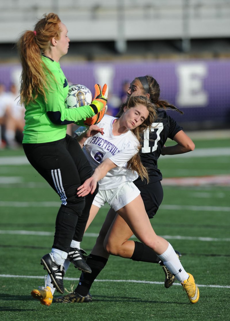 Fayetteville goalkeeper Gracie Cape (left) collides Tuesday with midfielder Avery Tubb (center) as Bentonville’s Victoria Mitchell takes a shot on goal during the first half at Harmon Stadium in Fayetteville. Visit nwadg.com/photos to see more photographs from the matches.