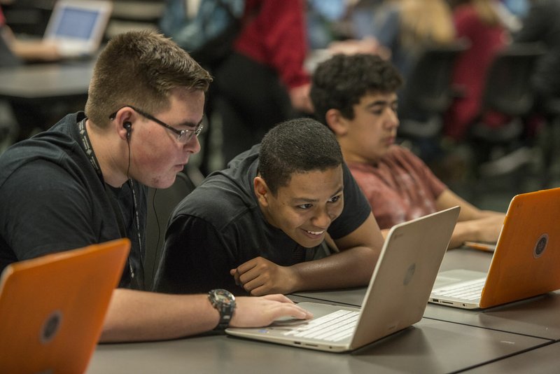 Jordan Weaver (left) and Cesar Moradel look at course work on a computer Tuesday at Springdale’s School of Innovation at The Jones Center. The pair were both working on getting caught up in their history class. The school will move to its new campus in east Springdale in August.