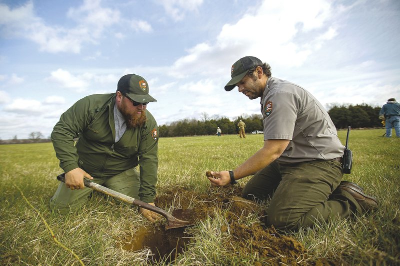 Alex Swift (left), Pea Ridge park interpreter, and Nolan Moore, park biologist, unearth a piece of case shot in Ruddick’s Field. Union troops fired their cannons on Confederate forces for two hours from a ridge as they pushed back a rebel advance.