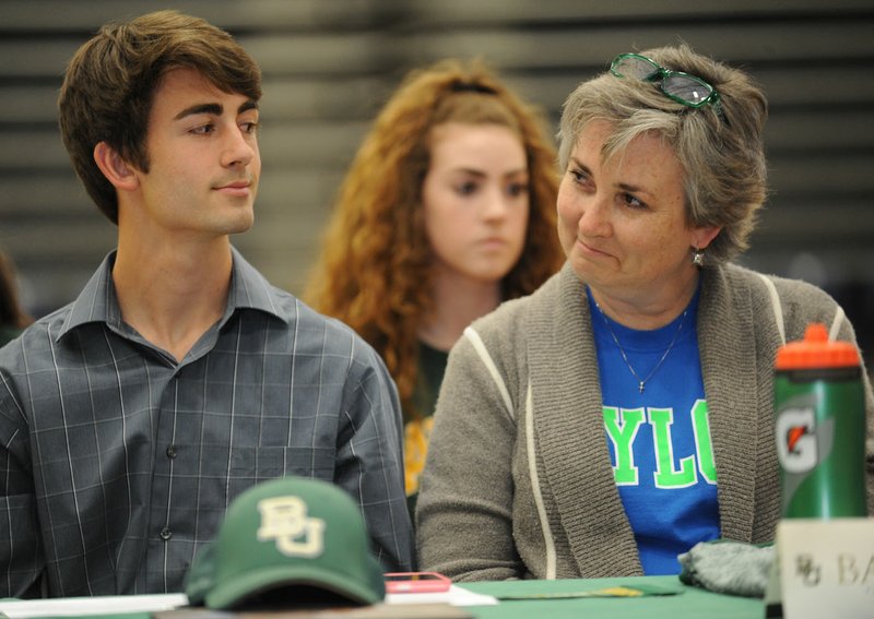 TJ Sugg and his mother, Jennifer, smile at each other Wednesday before TJ signs a letter of intent a to run for Baylor during a ceremony at Har-Ber High School in Springdale.