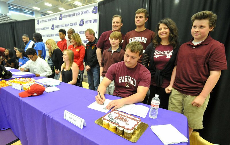 Blake Young, Fayetteville track and field shot put/discus signee, signs his letter of intent to attend Harvard during a signing day Wednesday while surrounded by his family Deryn (from left) Brooks, Ben, Jennifer and Braxton at Fayetteville High School.