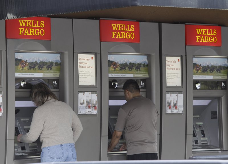 In this April 18, 2011 file photo, customers use Wells Fargo Bank ATM machines in Santa Clara, Calif. JPMorgan Chase, Bank of America, Wells Fargo, Bank of New York Mellon and State Street were cited Wednesday, April 13, 2016 by the Federal Reserve and the Federal Deposit Insurance Corp. for gaps in their bankruptcy plans known as "living wills" that they were required to submit. 