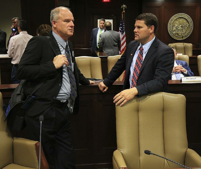 Sen. Jim Hendren (left) talks Thursday with Sen. Bart Hester at the state Capitol after the Joint Budget Committee fell seven votes short of approving Hendren’s amendment to prohibit the Medical Services Division from spending funds on the Medicaid expansion. Earlier, the bill failed to clear the Senate.