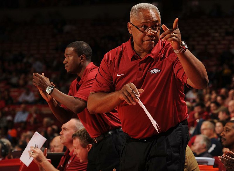 Melvin Watkins (front) and T.J. Cleveland (left), who have been assistants for Arkansas Coach Mike Anderson for 10 and 14 years, respectively, will remain in their roles despite Anderson’s addition of former Razorback Scotty Thurman to the coaching staff.