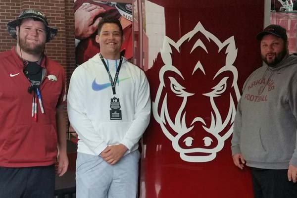 Festus (Mo.) Jefferson offensive lineman Shane Clenin, who committed to Arkansas on Saturday, April 16, 2016, poses with Arkansas offensive line coach Kurt Anderson (right) and graduate assistant Brey Cook (left).