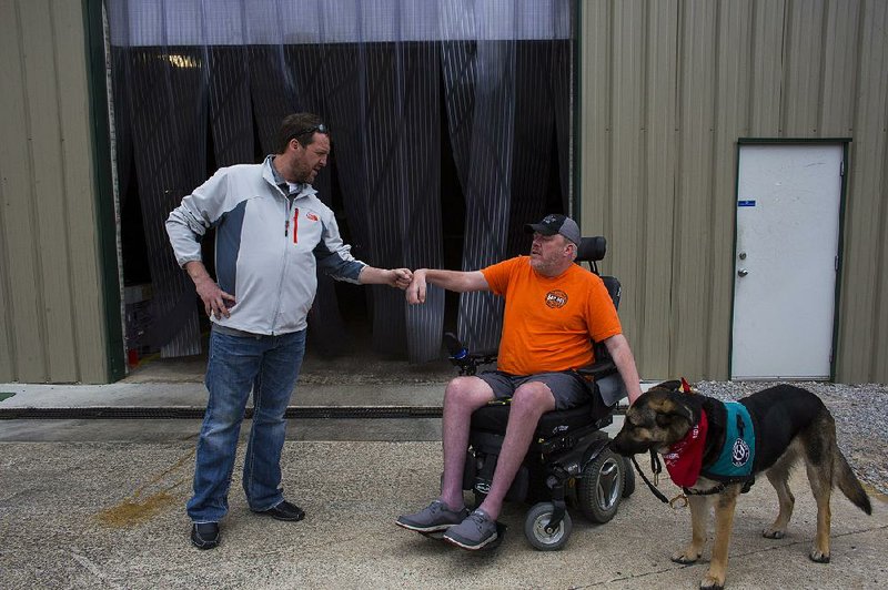 Kevin Thompson and his service dog, Dyson, say goodbye to Wes Hubbard of Bad Boy Mowers after the longtime friends spent a day at the Batesville plant.Thompson, an unpaid consultant of sorts at the plant, said the involvement offers a powerful distraction. Hubbard said he learns a lot from Thompson.