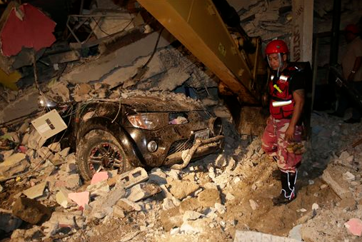 A rescue worker searches in the rubble of a destroyed house in Pedernales, Ecuador, on Sunday, April 17, 2016. The strongest earthquake to hit Ecuador in decades flattened buildings and buckled highways along its Pacific coast and sent the Andean nation into a state of emergency.