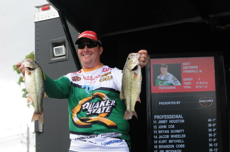 Tournament leader Scott Canterbury of Springville, Ala., shows two bass from his Saturday April 16, 2016 catch of 14 pounds, 6 ounces that moved him from second place on Friday to first on Saturday. 