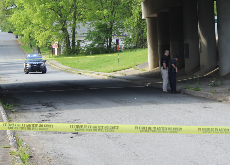 Little Rock police detectives investigate a crime scene near where a man was found dead from a gunshot wound Sunday morning.