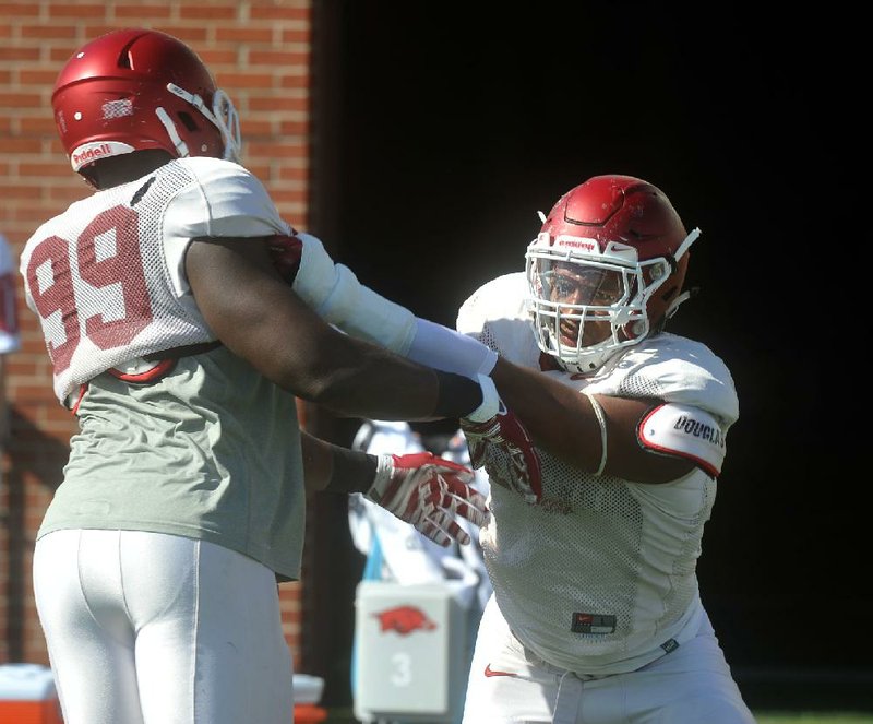 Arkansas defensive lineman Deatrich Wise (right) runs drills April 7 during practice in Fayetteville.