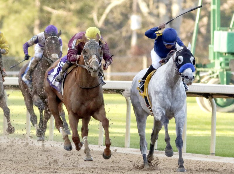 In this March 19, 2016, file photo, Cupid and jockey Martin Garcia, right, battles Whitmore and jockey Irad Ortiz, Jr., center, down the stretch to win the Rebel Stakes horse race at Oaklawn Park in Hot Springs, Ark. 