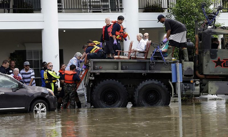 Residents are evacuated from a retirement and assisted-living complex as floodwaters rise Tuesday in Spring, Texas.