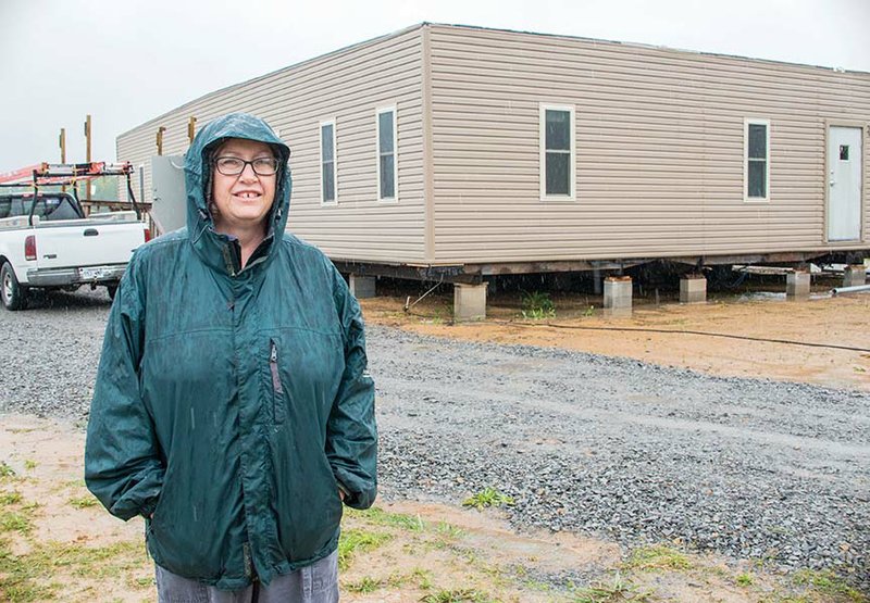 Kathy Thompson, executive assistant for the Community Life Skills Outreach Center, stands in front of the donated building that she is overseeing that will house people who were homeless and others who need assistance in the community.