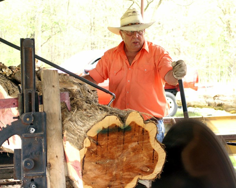 Jamie Smilie, of Inola, Okla., operated the saw mill and cut a cedar log at the Tired Iron of the Ozarks Antique Engine and Tractor Show in Gentry on Saturday.