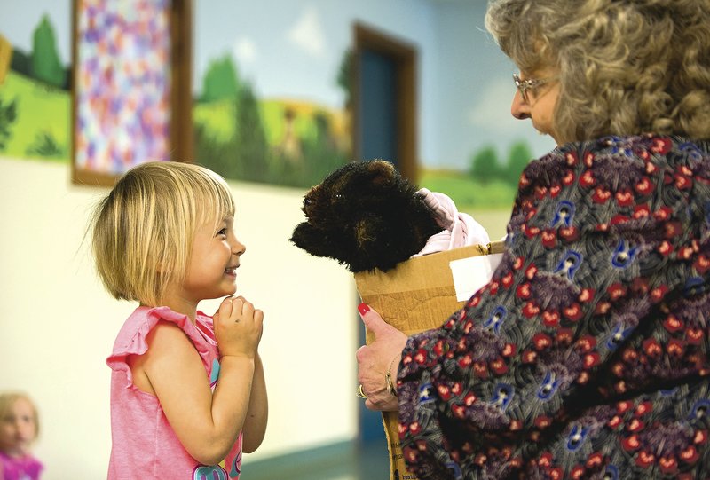 Kimber Senseney, 4, talks with “Brown Bear,” a puppet held by director Cindy Singleton on Monday at the Helen R. Walton Children’s Enrichment Center in Bentonville.