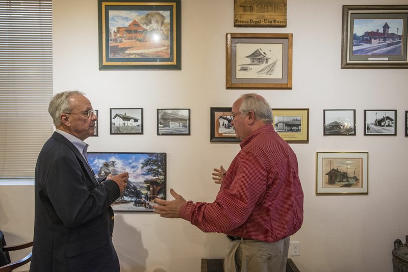 Dick Hovey (left), president of the J. Reilly McCarren Transportation Museum, and Chuck Girard, volunteer passenger conductor for the Arkansas & Missouri Railroad, talk Thursday about some of the photos on display for the opening of the museum at the A&M Railroad depot in Springdale. The museum is sponsored by the Friends of the Arkansas Missouri Railroad and features several exhibits highlighting the past of passenger and freight trains. Exhibits include antique locomotive lights, lanterns, serving wear, uniforms and an interactive locomotive control.