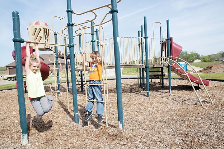 Chloe McGee, 8, and her 7-year-old brother, Jackson, play together in a memorial park in the Parkwood Meadows subdivision in Vilonia. Master Sgt. Daniel Wassom II was killed on the property in his home during the April 27, 2014, tornado. His widow, Suzanne, donated the lot to create a memorial park dedicated to her husband and the seven other Vilonia victims. The McGee children said they were home when the tornado hit the neighborhood, destroying their house. Chloe said their house was one of the first to be rebuilt, and they are happy to be back home.